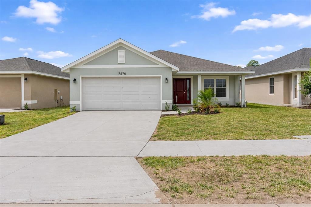 a front view of a house with a yard and garage