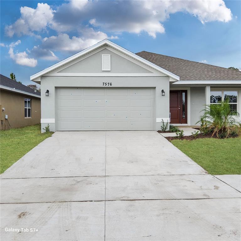 7576 Bent Tree Loop St. Cloud, FL 34773 - Photo 1 of 18 a front view of a house with a yard and garage