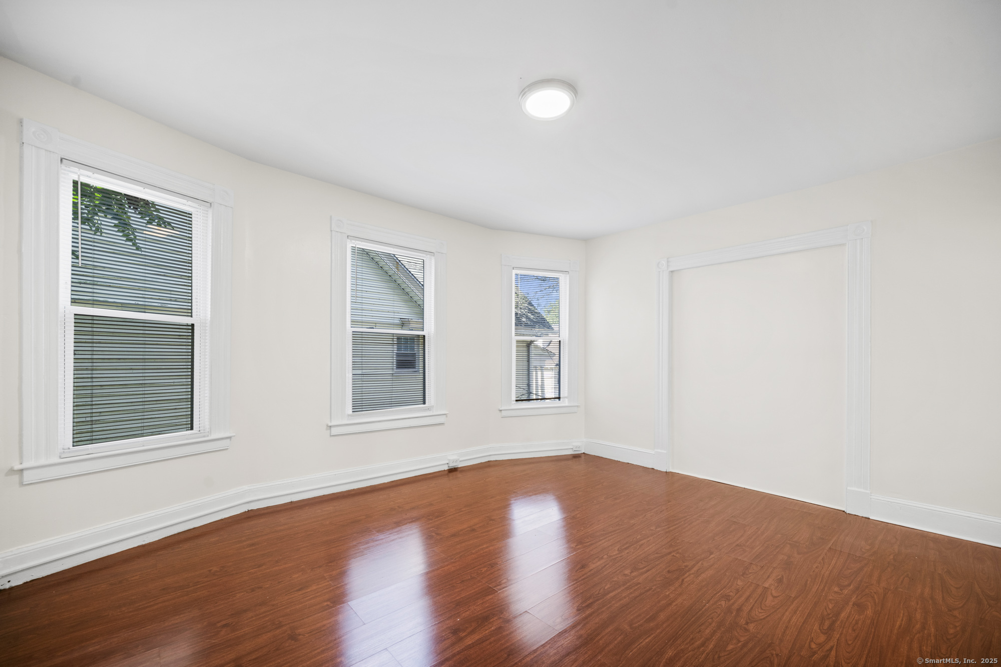 217 Woodlawn Terrace Waterbury, CT 06710 - Photo 8 of 9 a view of an empty room with wooden floor and a window