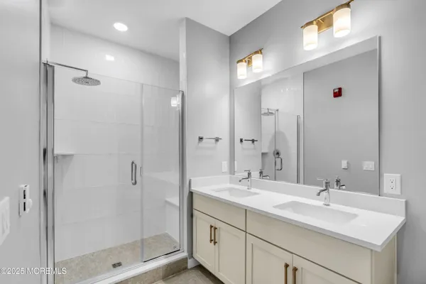 a bathroom with a shower sink vanity and mirror