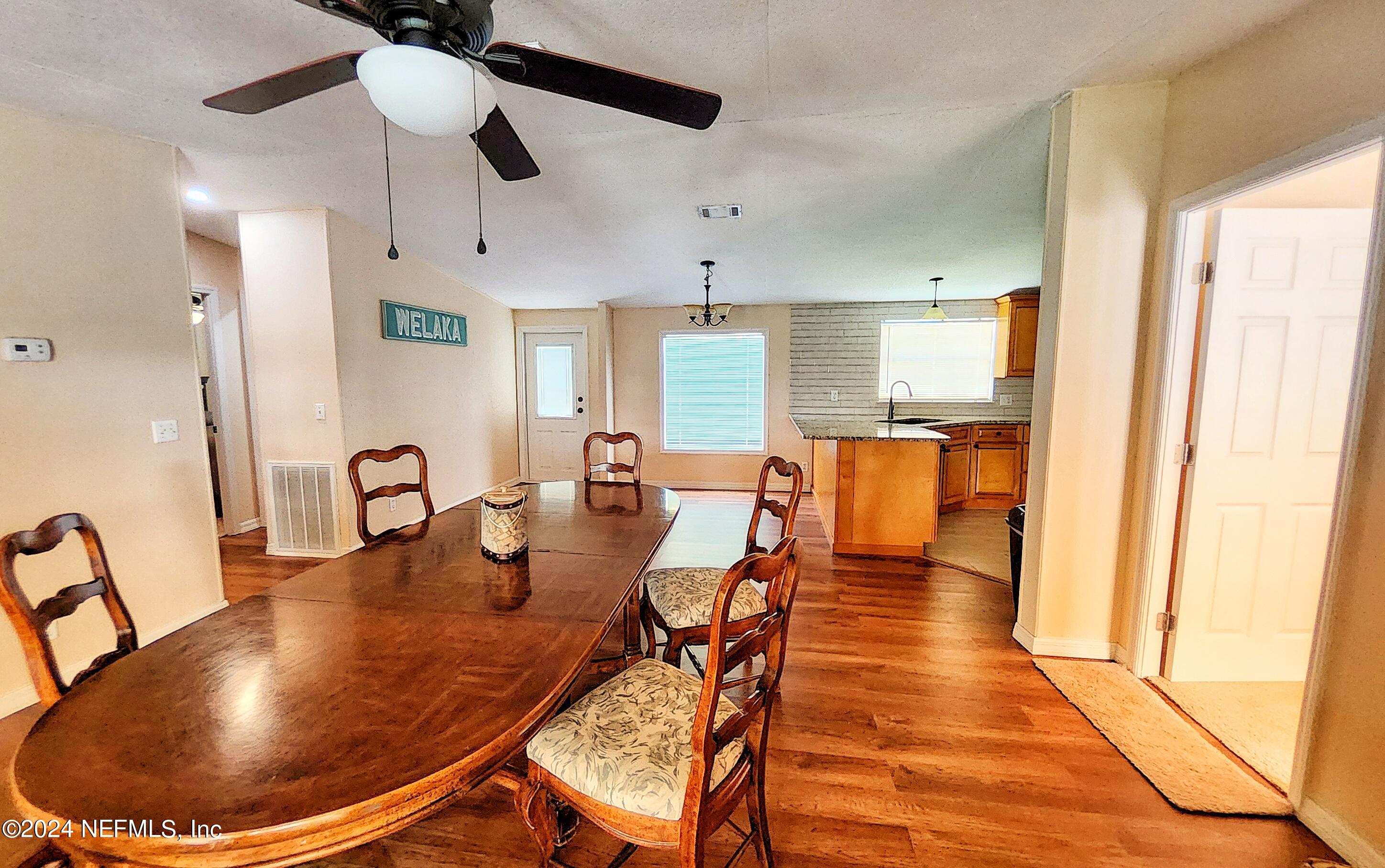 44 Scott Welaka, FL 32193 - Photo 24 of 35 a dining room with stainless steel appliances kitchen island granite countertop a table chairs and a refrigerator