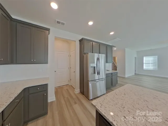 a kitchen with refrigerator cabinets and wooden floor