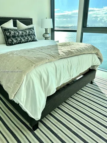 a bed sitting in a bedroom next to a window