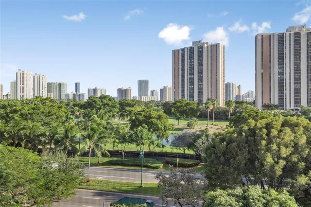 a view of a city with tall buildings and a big yard