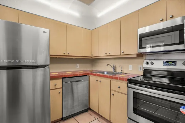 a kitchen with stainless steel appliances white cabinets and a stove a refrigerator with wooden floors
