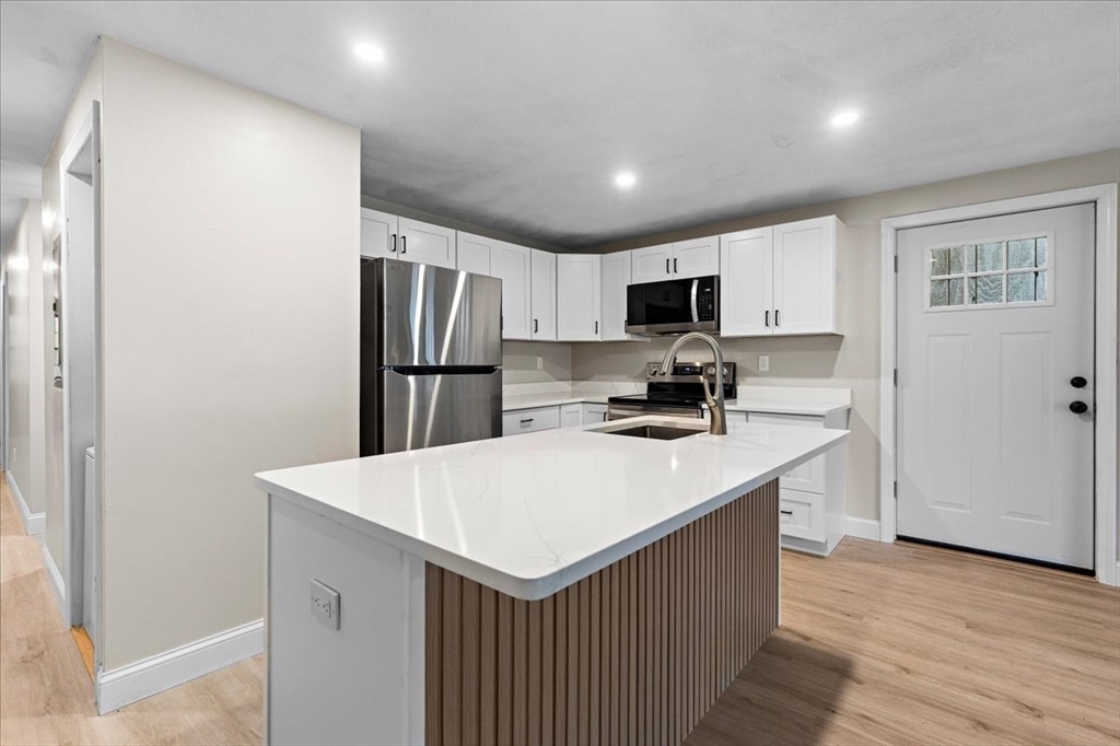 a kitchen with a refrigerator a sink a stove a microwave and cabinets