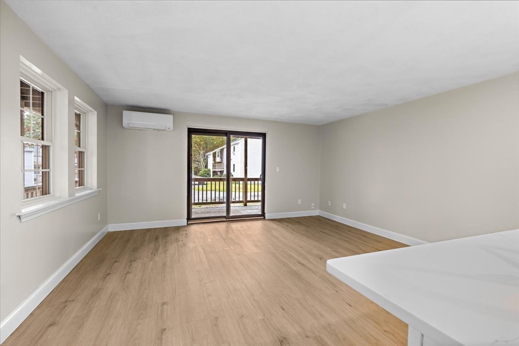 35 Ashumet Road, Unit 11B Mashpee, MA 02649 - Photo 10 of 24 an empty room with wooden floor and windows