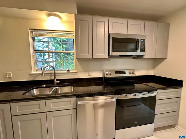 a kitchen with a sink stove and microwave
