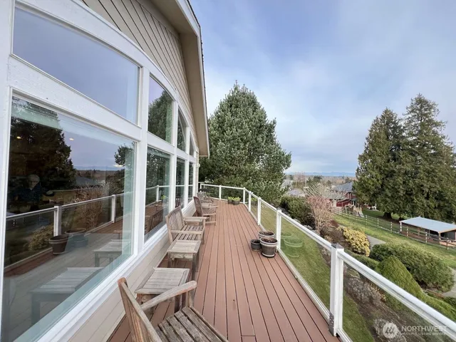 a view of a balcony with chairs and wooden floor