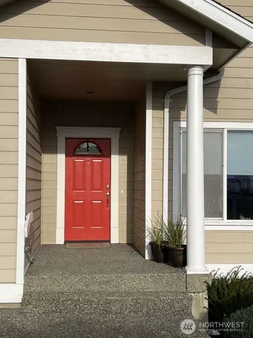 a view of a house with a yard and potted plants