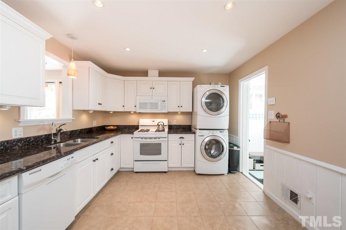 2213 Mossbank Road Raleigh, NC 27604 - Photo 12 of 28 a kitchen with granite countertop a white stove top oven sink and cabinets