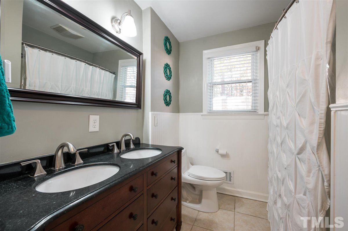 2213 Mossbank Road Raleigh, NC 27604 - Photo 17 of 28 a bathroom with a granite countertop sink a toilet and a mirror