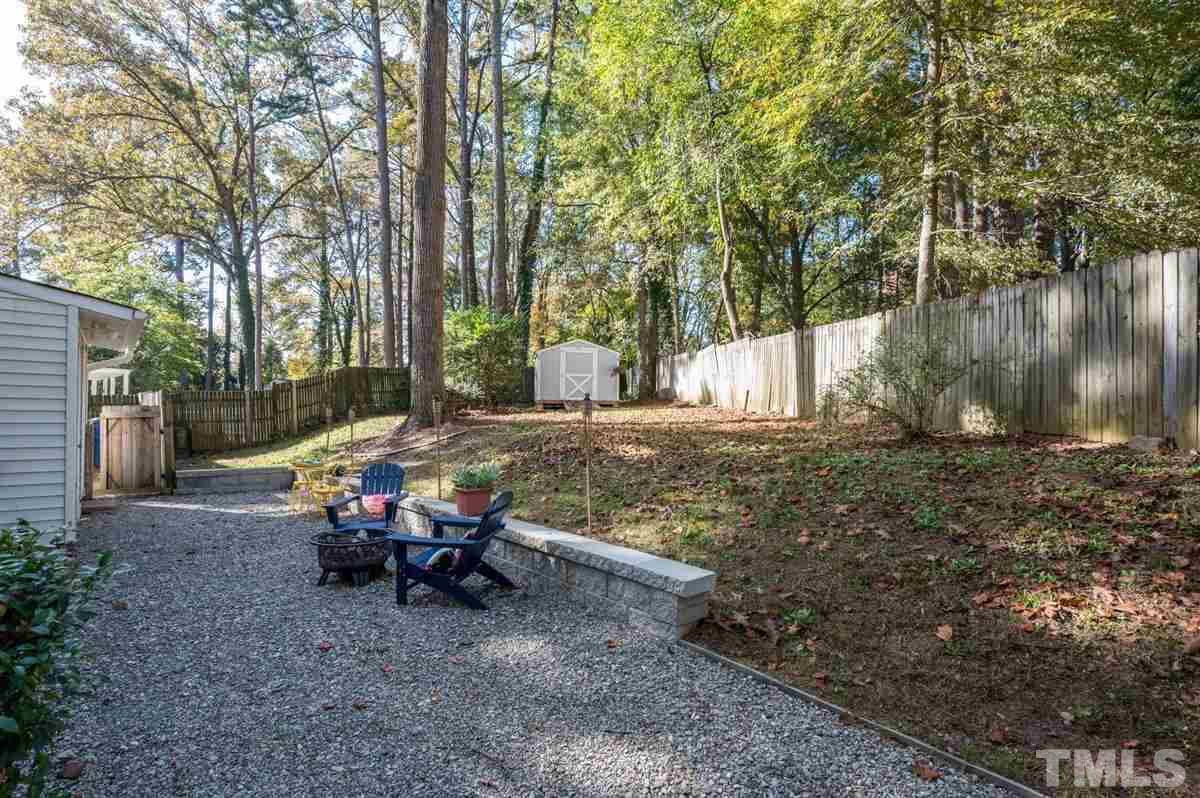 2213 Mossbank Road Raleigh, NC 27604 - Photo 24 of 28 a view of backyard with table and chairs and a large tree