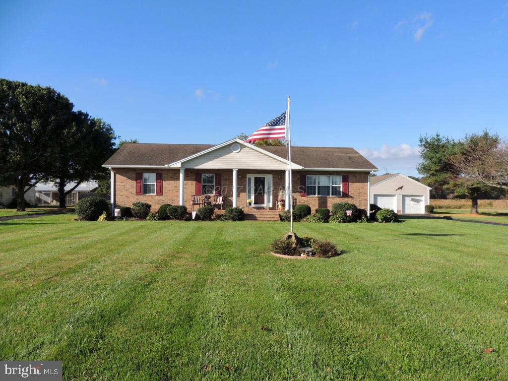 6782 Bent Pine Road Willards, MD 21874 - Photo 1 of 21 a front view of a house with a yard table and chairs