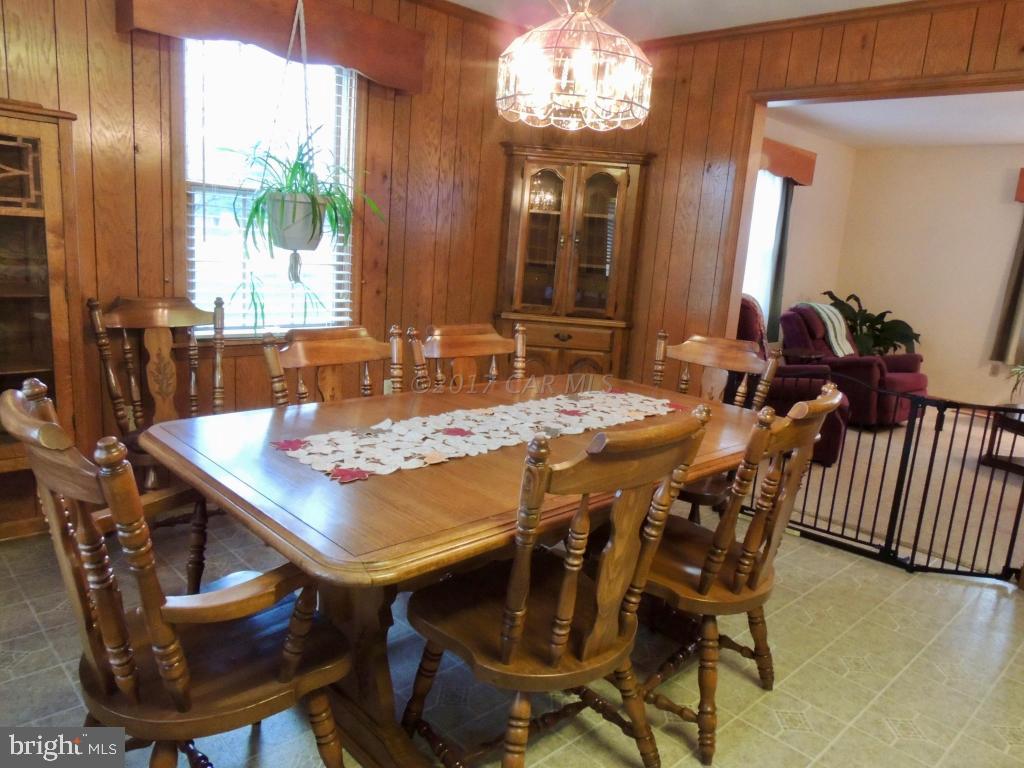 6782 Bent Pine Road Willards, MD 21874 - Photo 7 of 21 a view of a dining room with furniture a chandelier and wooden floor