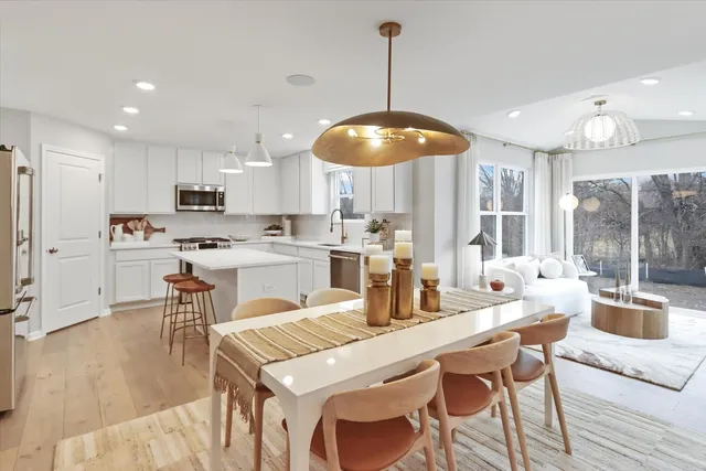 a kitchen with a dining table chairs and white cabinets