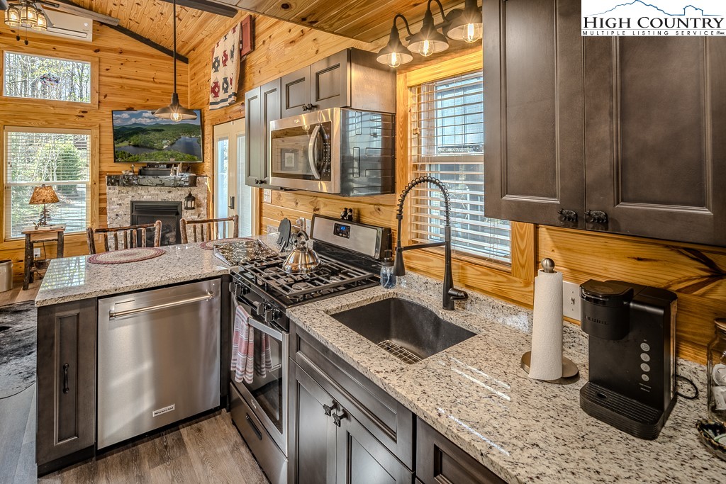 793 Highland Hills Road Newland, NC 28657 - Photo 17 of 40 a kitchen with granite countertop a sink and a stove top oven