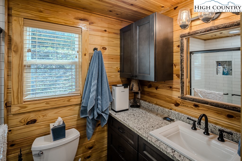 793 Highland Hills Road Newland, NC 28657 - Photo 18 of 40 a bathroom with a granite countertop sink and a mirror
