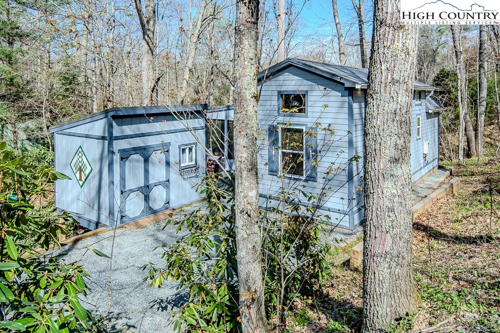 793 Highland Hills Road Newland, NC 28657 - Photo 4 of 40 a view of a wooden house with a yard and large trees