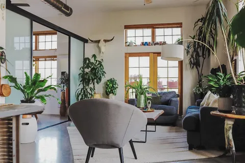 a living room with patio furniture and a potted plant