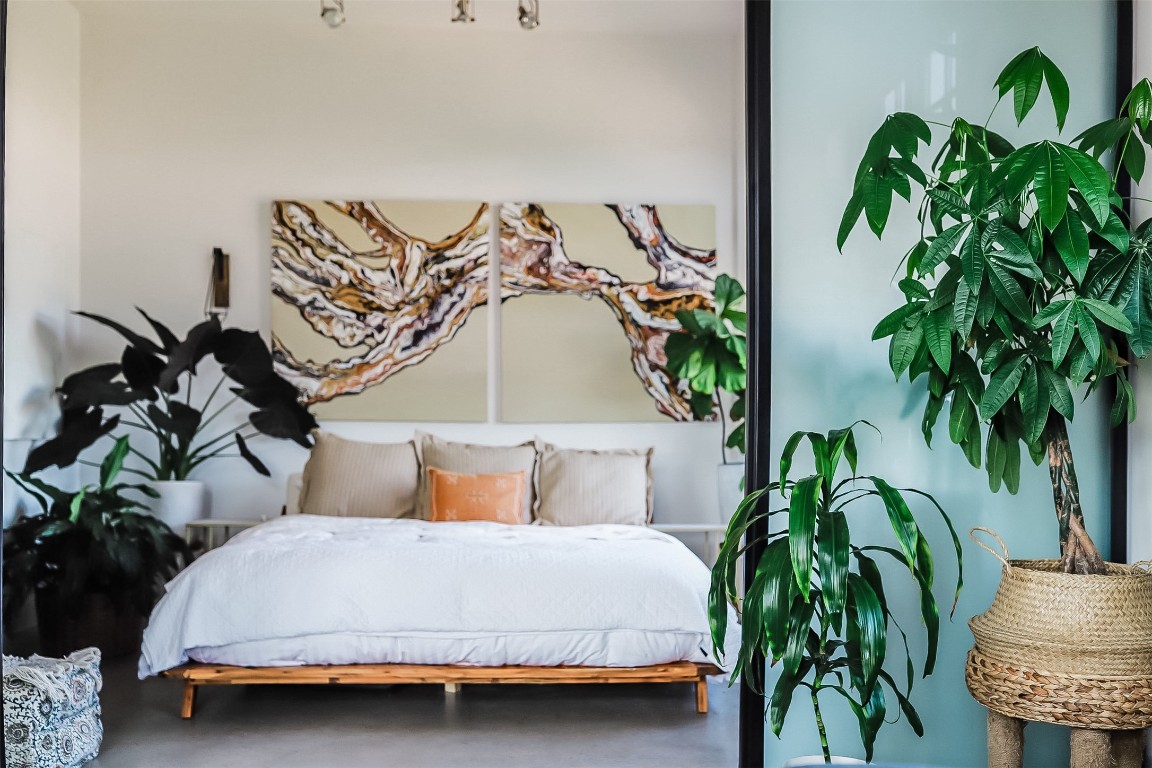 2235 East 6th Street, Unit 404 Austin, TX 78702 - Photo 21 of 37 a bedroom with a bed and a plant