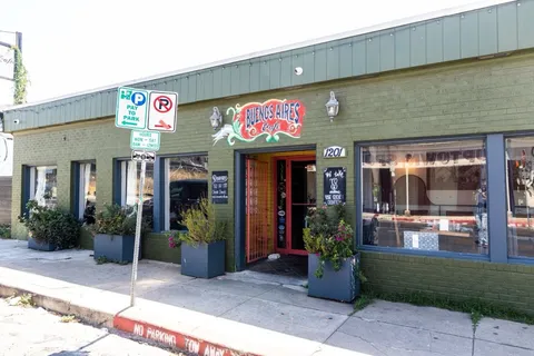 a view of a house with a potted plant ana a small yard