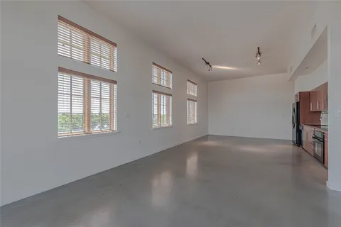 a view of a livingroom with an empty space and a window