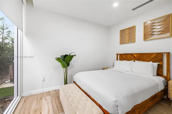 a bedroom with a bed and a painting on the wall