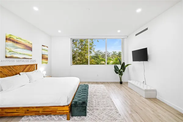 a living room with a bed furniture and a flat screen tv