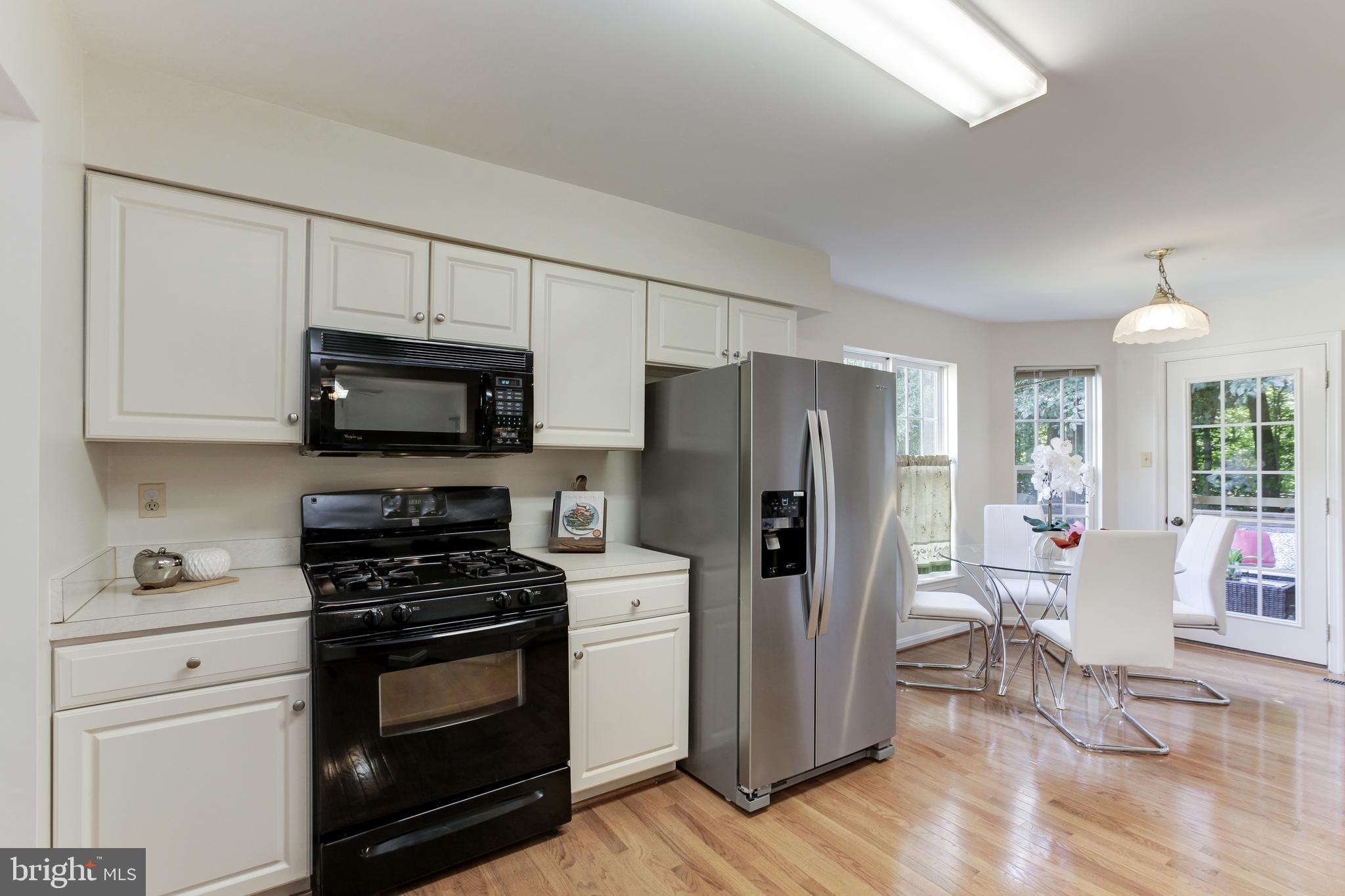 8014 Big Pool Road Laurel, MD 20724 - Photo 16 of 52 a kitchen with stainless steel appliances a refrigerator stove and white cabinets