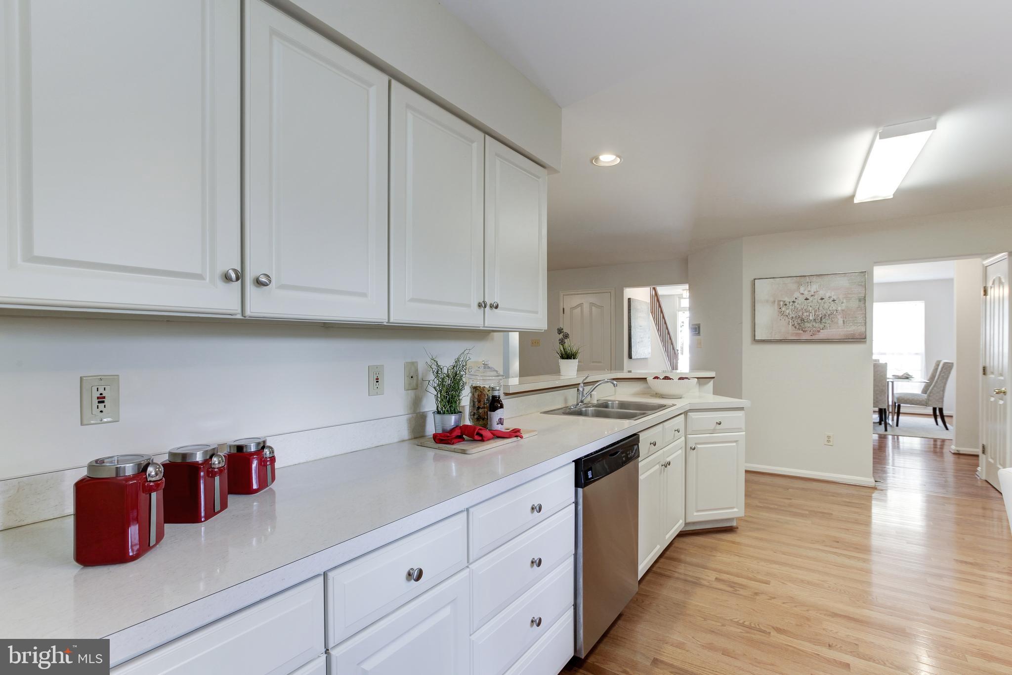 8014 Big Pool Road Laurel, MD 20724 - Photo 20 of 52 a kitchen with stainless steel appliances granite countertop a sink dishwasher and white cabinets with wooden floor