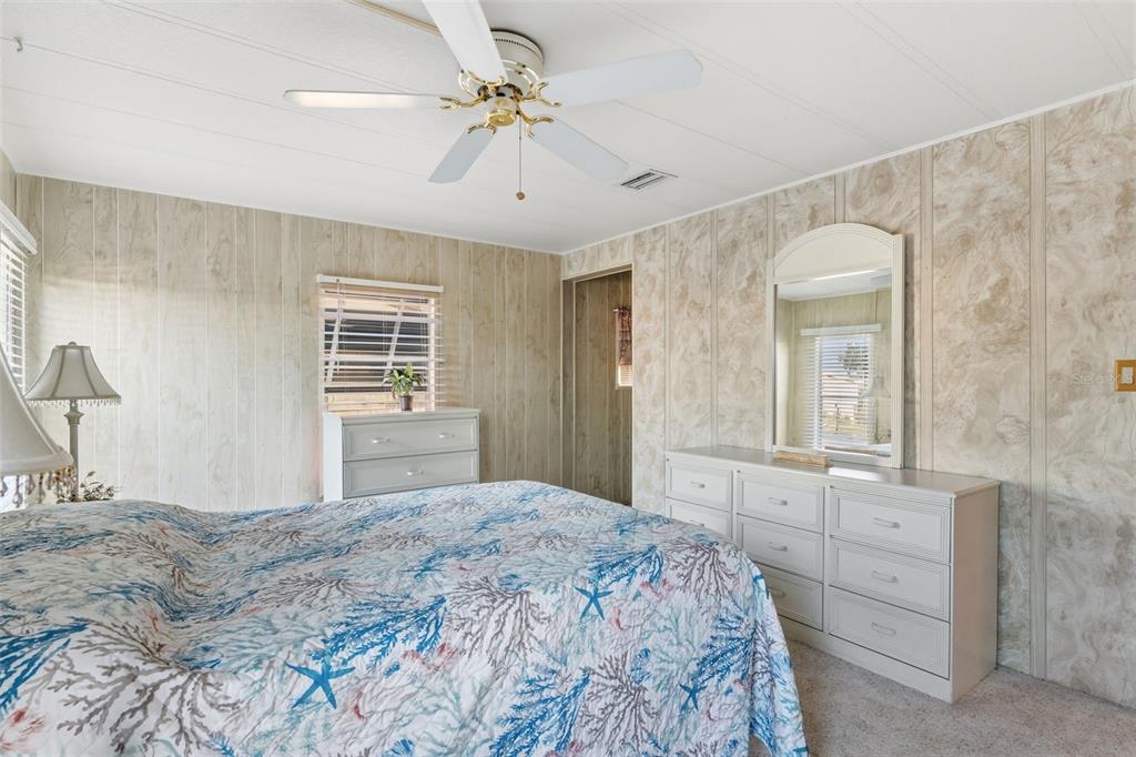 119 Lazy River Road North Port, FL 34287 - Photo 40 of 76 a bedroom with a large bed and a chandelier