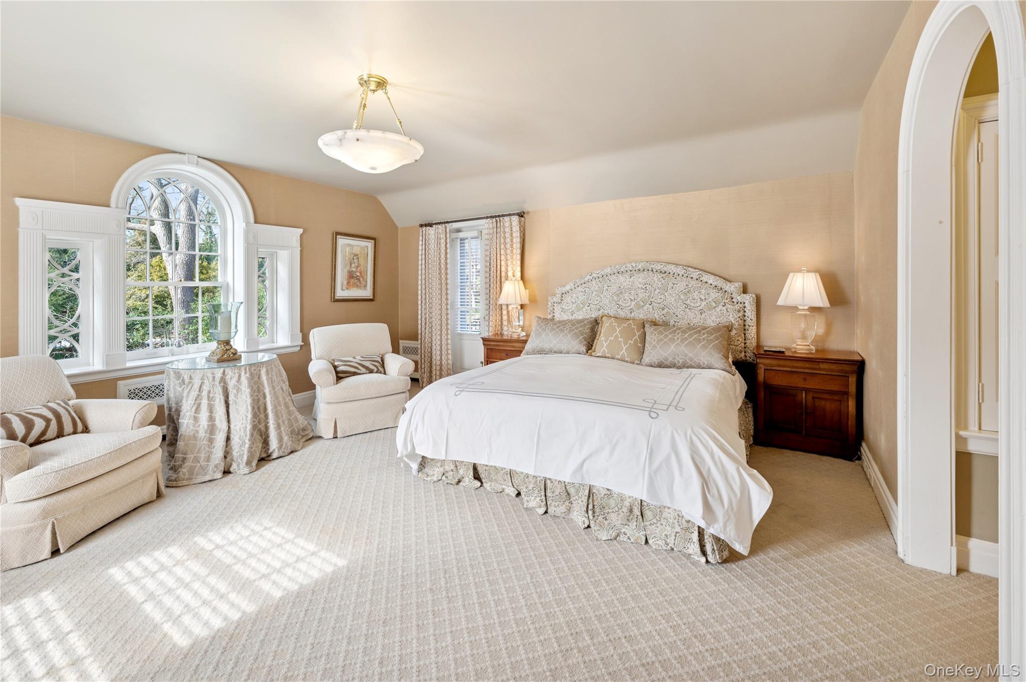 139 Hampshire Road Bronxville, NY 10708 - Photo 24 of 47 a spacious bedroom with a bed and a chandelier