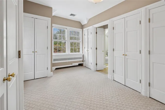 a view of empty room with white walls and window