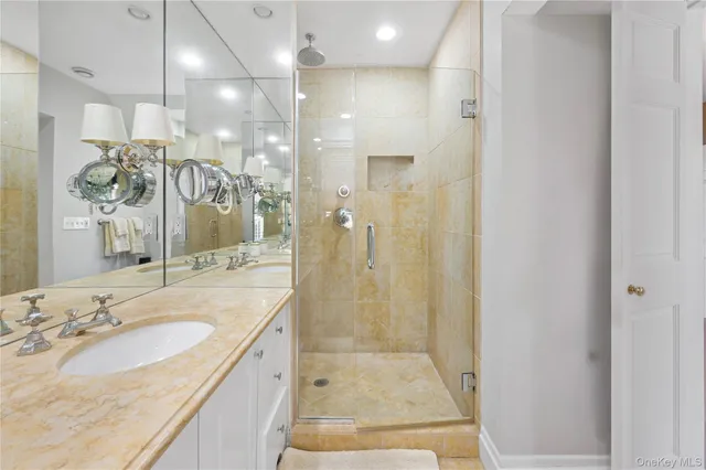 a bathroom with a granite countertop sink a shower and a mirror