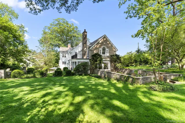 a view of a house with a big yard and large trees