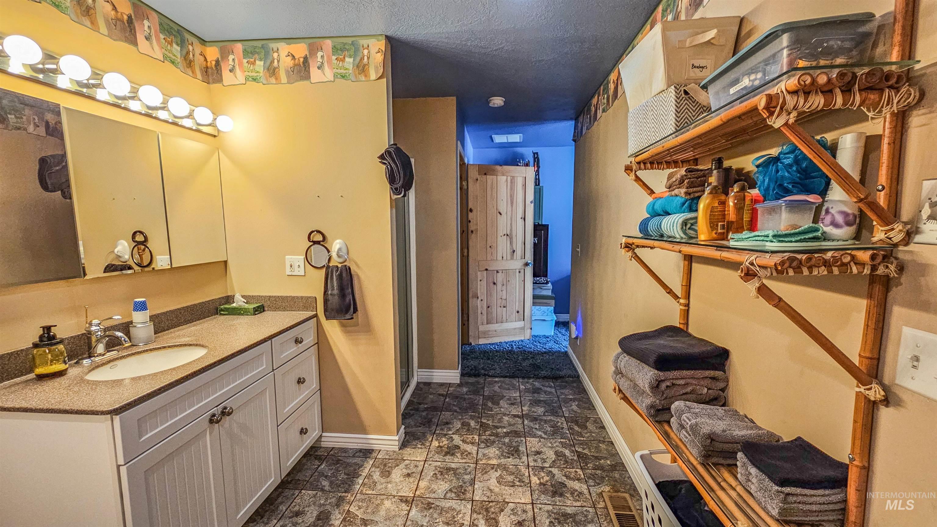 3382 Highway 21 Boise, ID 83716 - Photo 27 of 50 Bathroom featuring vanity, a shower with shower door, and stone finish flooring