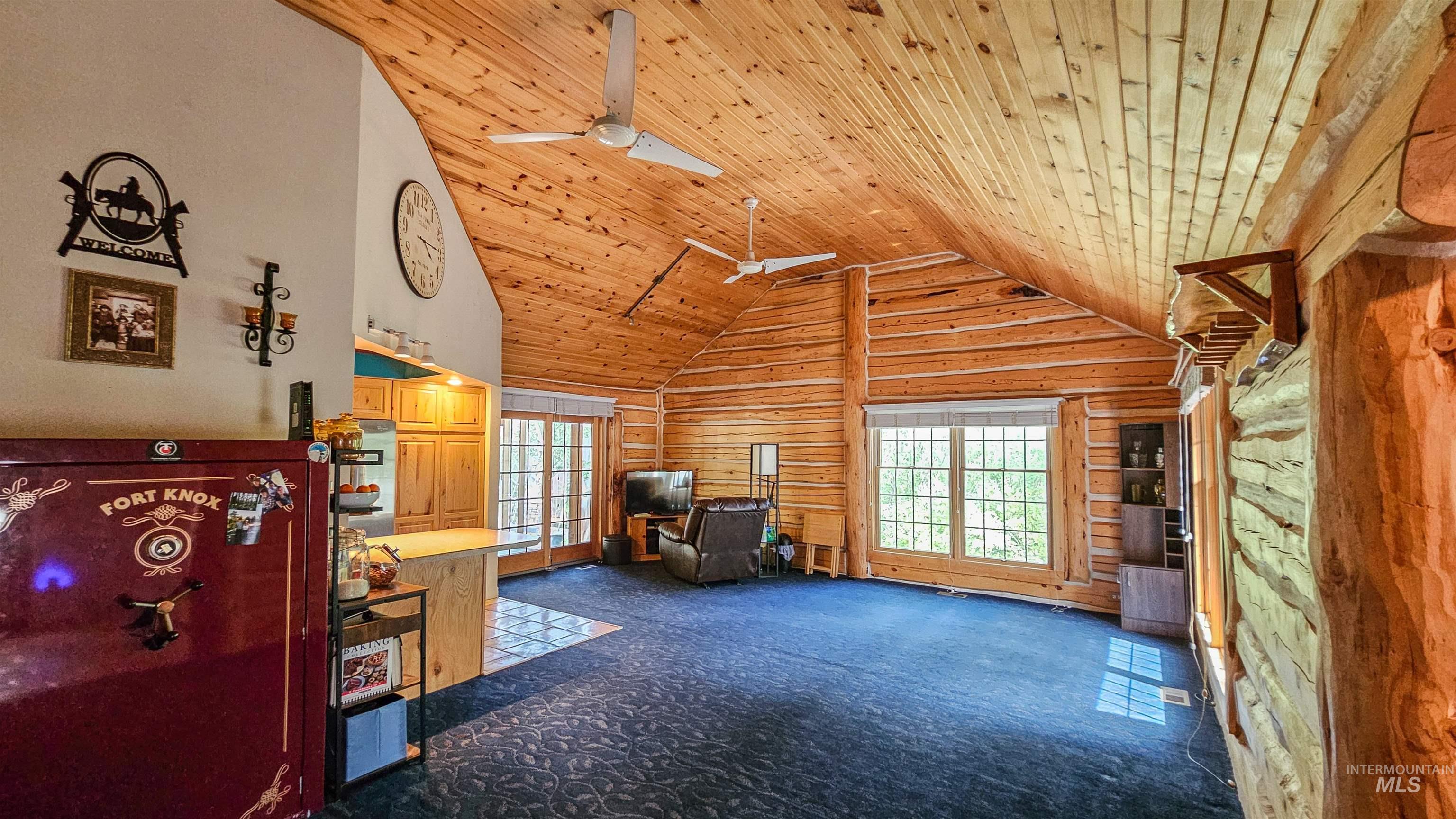 3382 Highway 21 Boise, ID 83716 - Photo 7 of 50 Carpeted living room with wooden ceiling, wooden walls, ceiling fan, high vaulted ceiling, and french doors