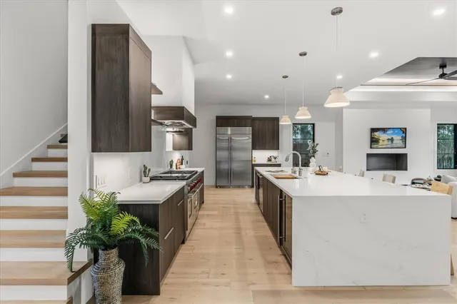 a large kitchen with stainless steel appliances kitchen island granite countertop a large counter top a stove and a sink