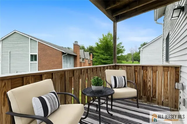 a balcony with wooden floor outdoor seating and stairs