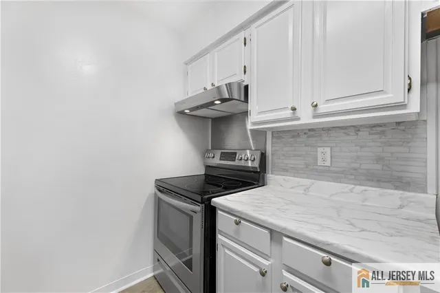 a kitchen with a stove and white cabinets