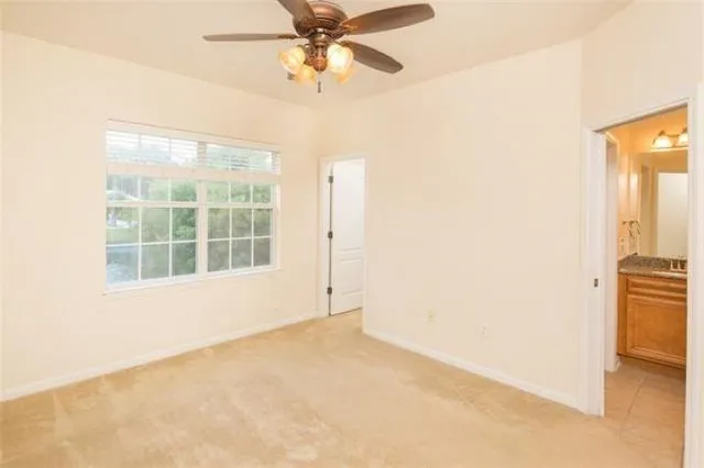 an empty room with a window and a fan