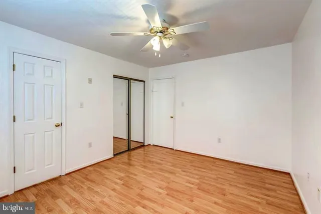 a view of an empty room with a chandelier fan