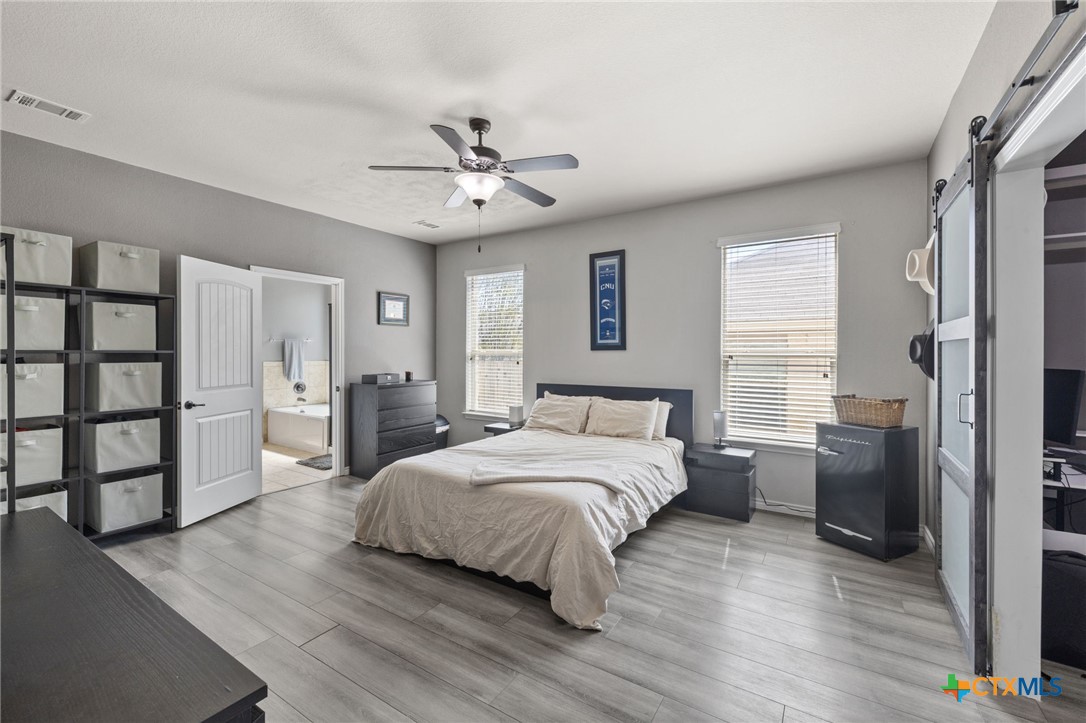 10113 Copper Ridge Cove Austin, TX 78747 - Photo 23 of 32 a bedroom with a bed and a window