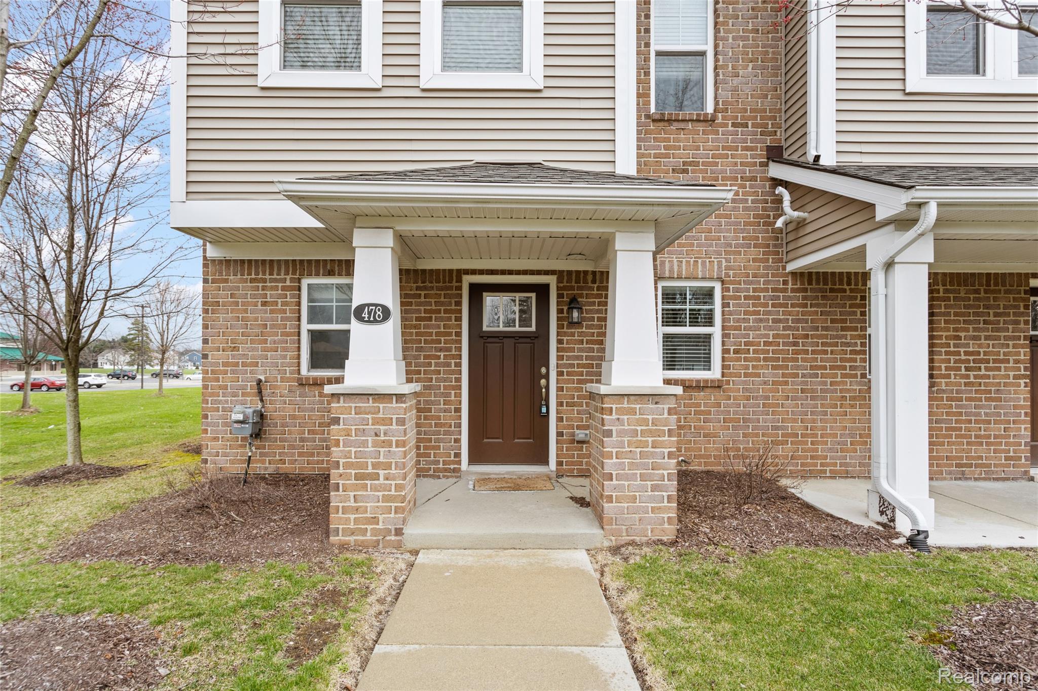 478 North Wixom Road Wixom, MI 48393 - Photo 2 of 26 View of exterior entry featuring brick siding, a yard, and a porch