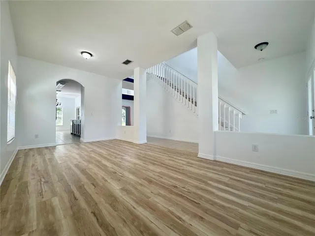 a view of empty room with wooden floor