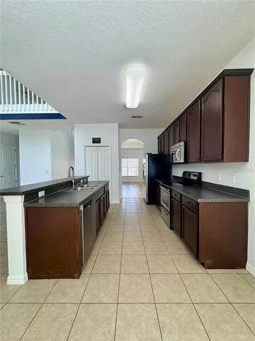 a kitchen with stainless steel appliances granite countertop a stove a sink and a microwave