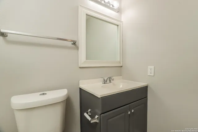a bathroom with a sink toilet and mirror