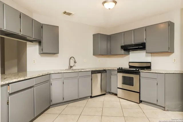 a kitchen with cabinets appliances and a sink
