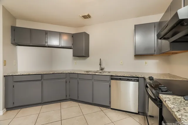 a kitchen with stainless steel appliances granite countertop a sink and a stove